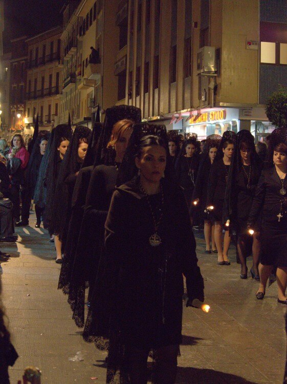 Women dressed in black marching in the procession.
