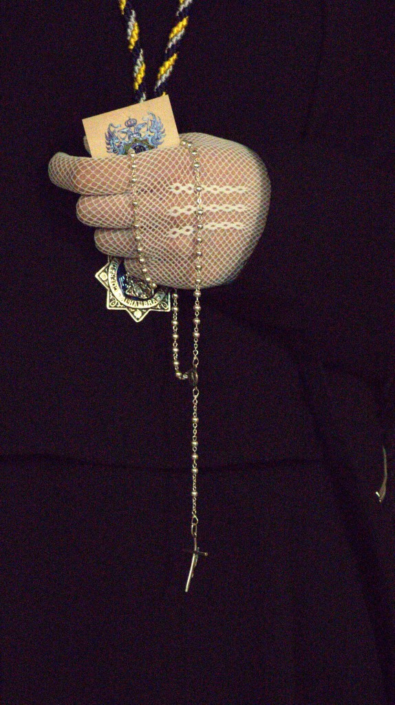 A woman carrying the rosary and a card with an image of Jesus or Mary.