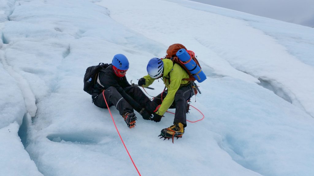 Pedr fixing his crampons on the ice.