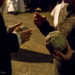 Two children comparing the size of their wax balls collected from penitents.