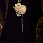 A woman marching in the Semana Santa procession clutches her holy objects close to her chest.