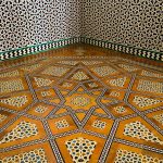 Intricate floor and wall tiling in Seville's Alcázar.