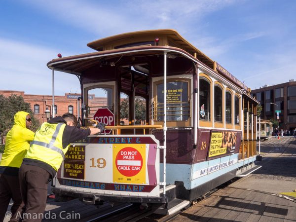 A picture of two operators pushing a cable car off the turntable.