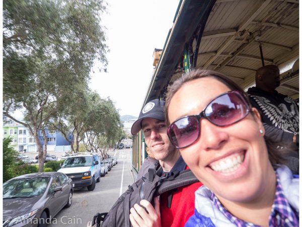 A picture of Amanda and Pedr hanging out the side of a cable car.