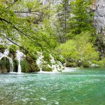 The stunning turquoise water and green foliage of Plitvička Lakes.