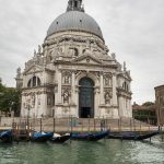 Gondolas parked outside of an extravagant church in Venice.