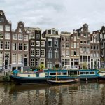 A typical Amsterdam canal with houseboats and canal houses.