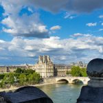A statue overlooking the Seine and the Louvre.