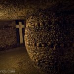Inside the Catacombs of Paris, the bones of the long dead are arranged into various formations.