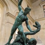 A bronze statue of Hercules fighting a snake, inside the Louvre Museum.