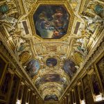 The richly decorated ceiling in the Apollo Gallery of the Louvre Museum.