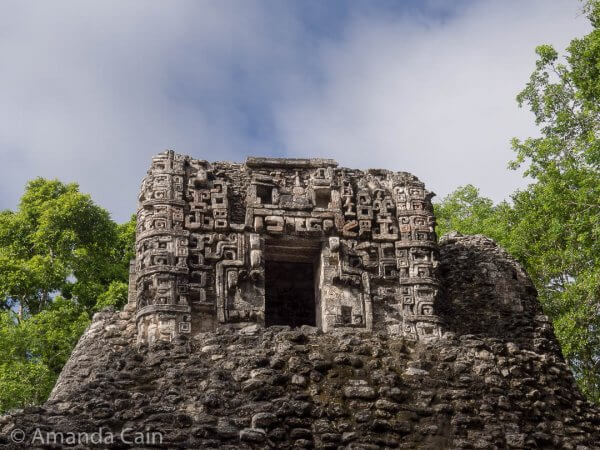 A highly decorated temple in Hormiguero. You can see a face above the door. The door is actually the mouth of the face, and it represents the portal to the underworld. You can also see smaller faces stacked along the side edges of the temple.